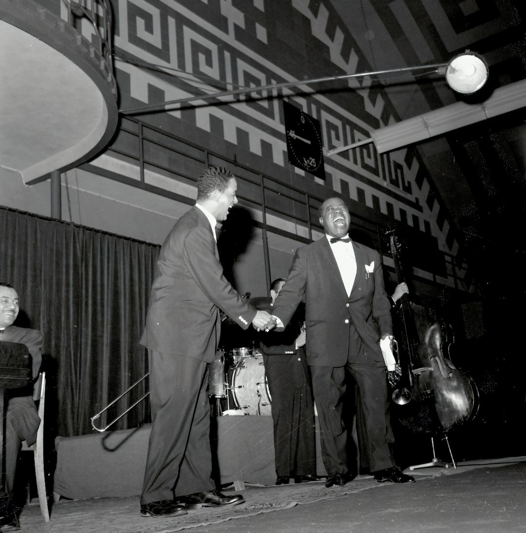 Two Swiss celebrities greeting each other warmly at an evening gala event