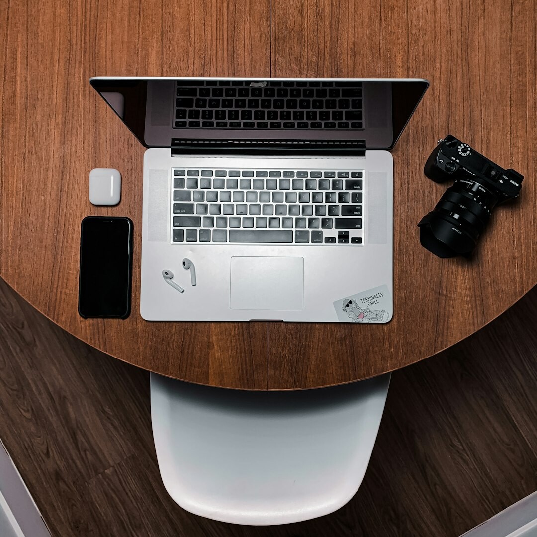 Small editorial team of journalists working together around a table with laptops